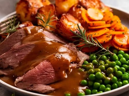 Roast lamb with gravy and mint sauce served with mash and peas