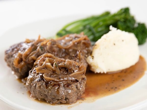 Braised Rissoles in an onion and bacon gravy with mashed potato and greens.