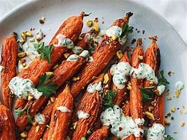 Roast carrots with herby yoghurt, harissa and pinenut butter